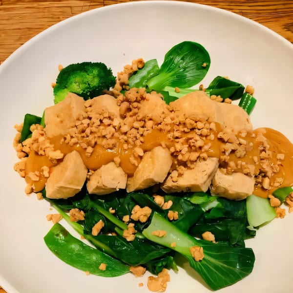 Thai Diva Cuisine's tofu with peanut sauce, broccoli, and bok choy on a white plate.