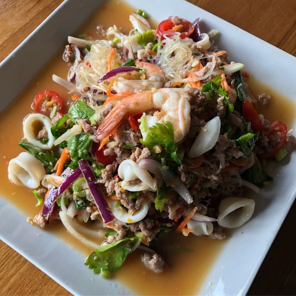 Thai glass noodle salad with shrimp, squid, minced pork, vegetables, and a savory dressing.